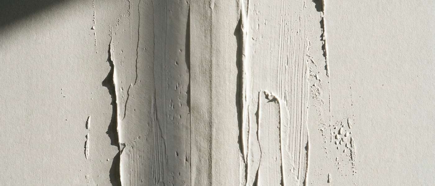Vertical joints on an interior wall where the seam coating and tape have lifted and flaked away from the drywall